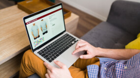 Adult man doing online shopping during a leisure day at home. Young man buying clothes online