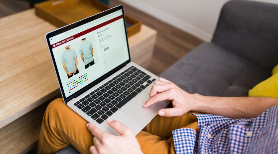 Adult man doing online shopping during a leisure day at home. Young man buying clothes online