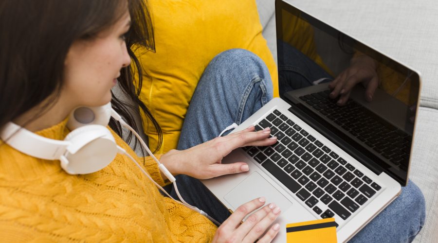 high-angle-woman-working-laptop-with-credit-card-top