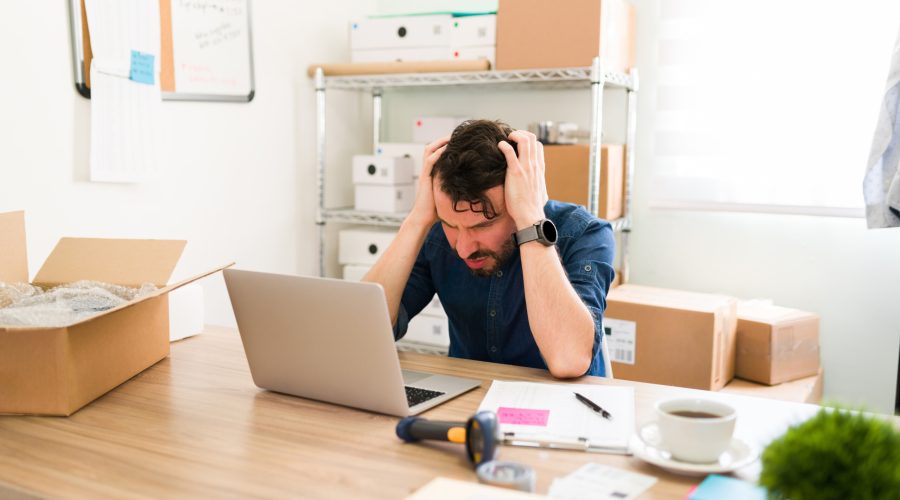 Hispanic business owner having problems with his startup company. Upset  entrepreneur feeling stressed and worried while looking at the laptop screen